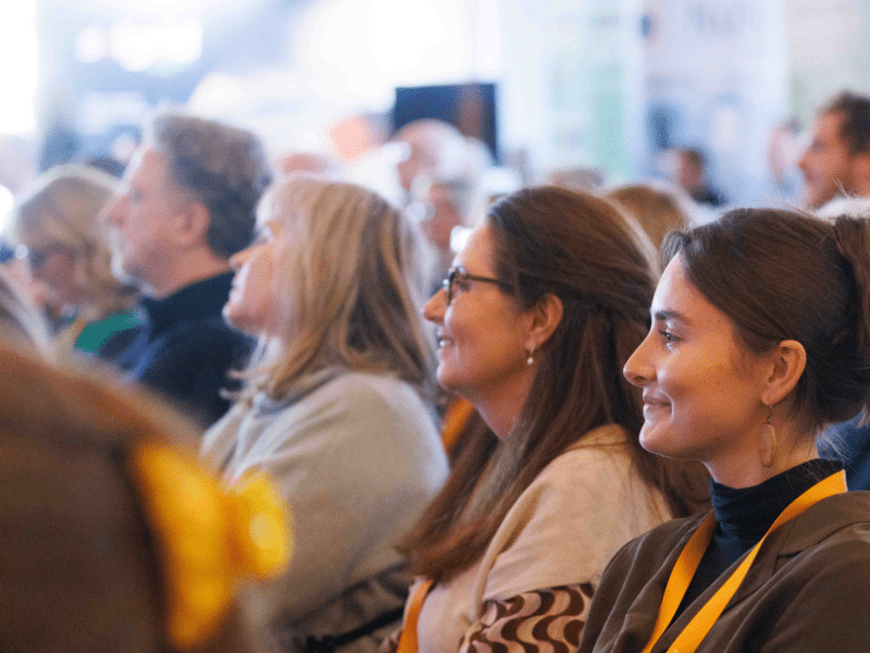 Attendees smiling looking towards stage